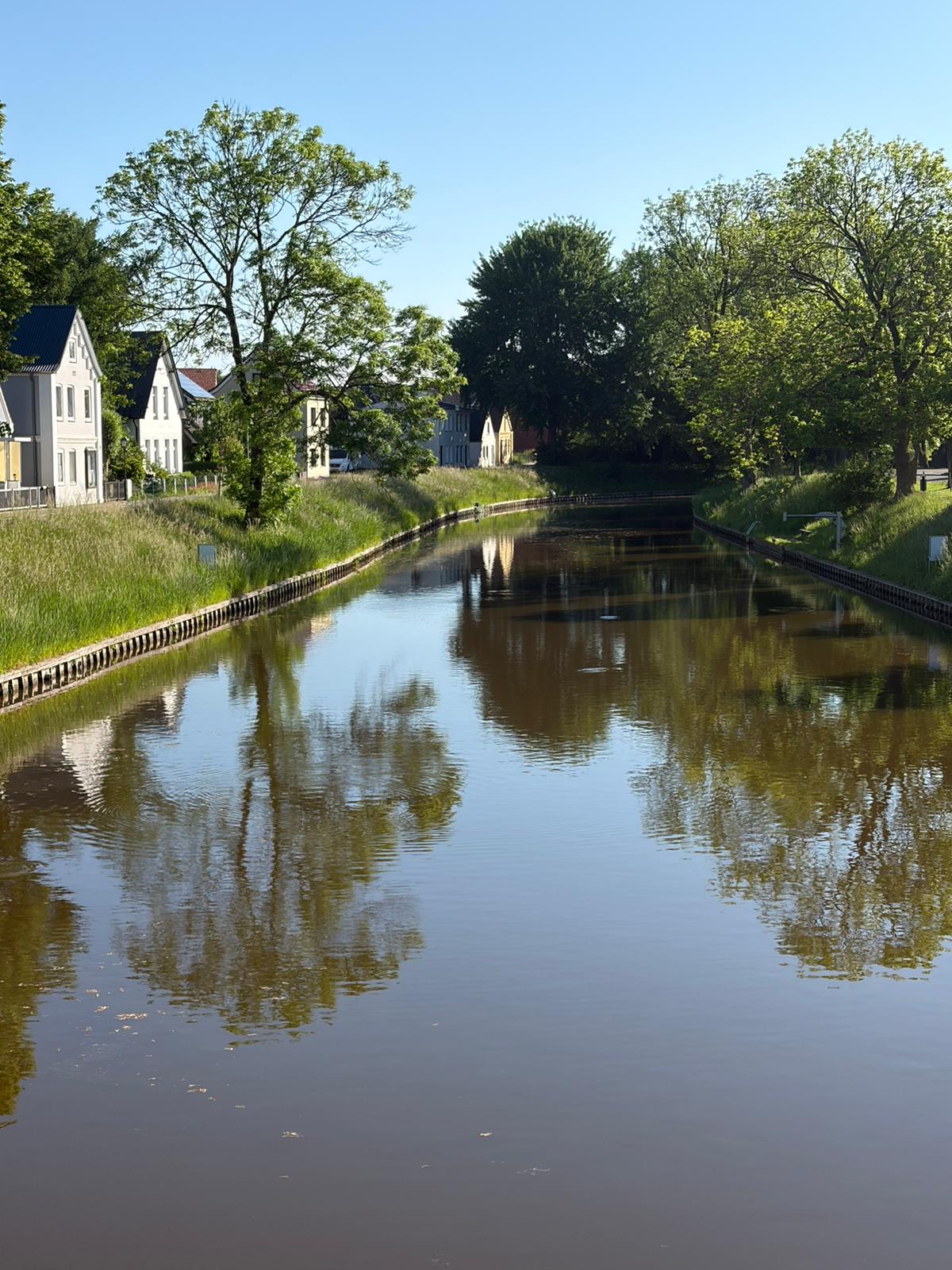 Ruhiger Wasserlauf mit historischen Häusern in Brunsbüttel