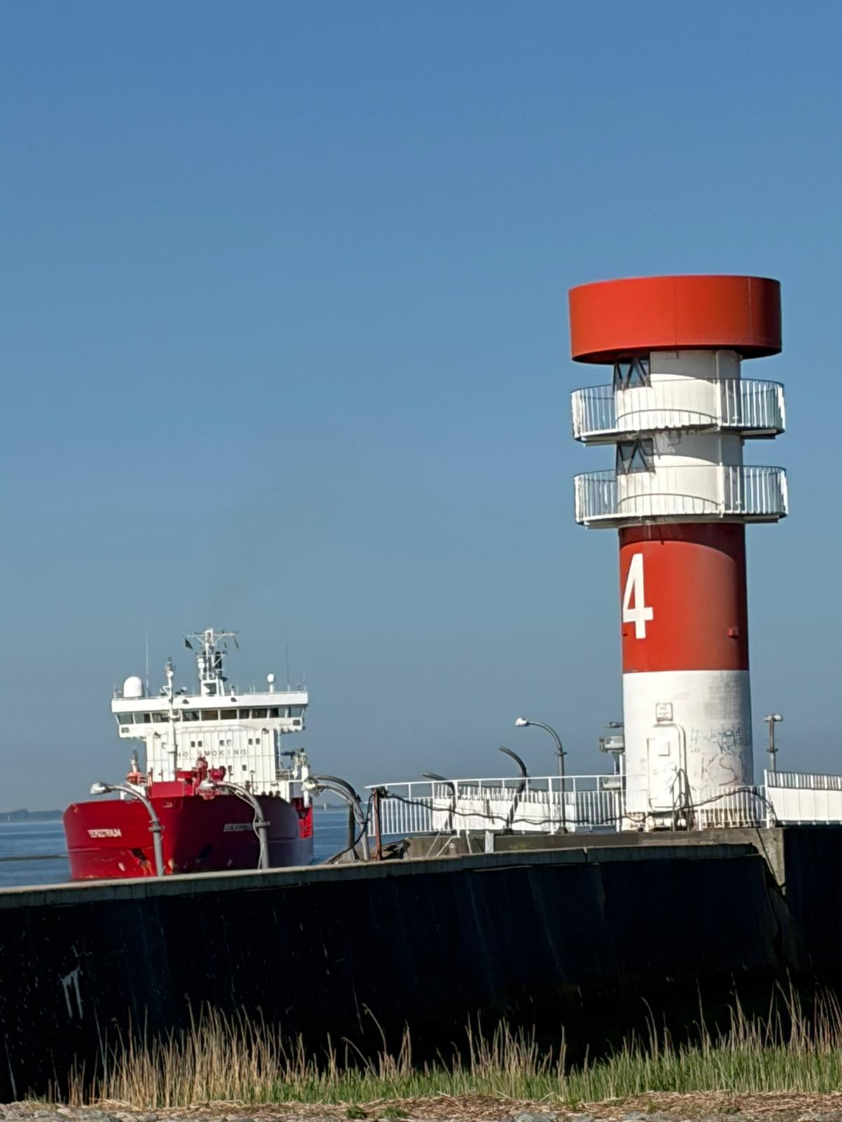 Frachtschiff und Leuchtfeuer am Elbufer