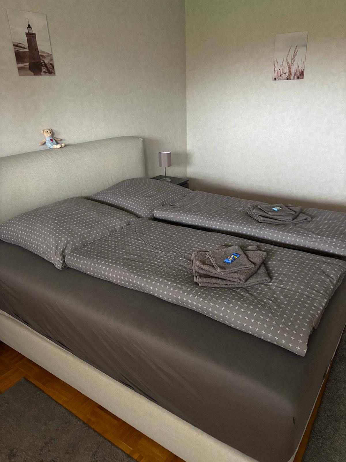 Schlafzimmer mit Boxspringbett und frischen Handtüchern